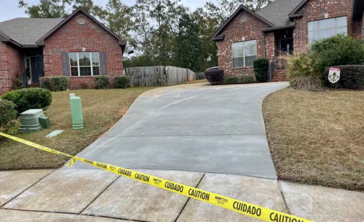 Concrete pathway resurfacing with yellow caution line across to warn people of wet cement